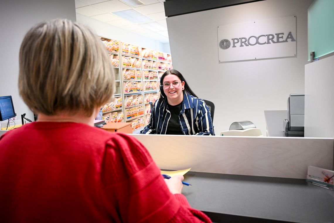 smiling receptionist greets woman